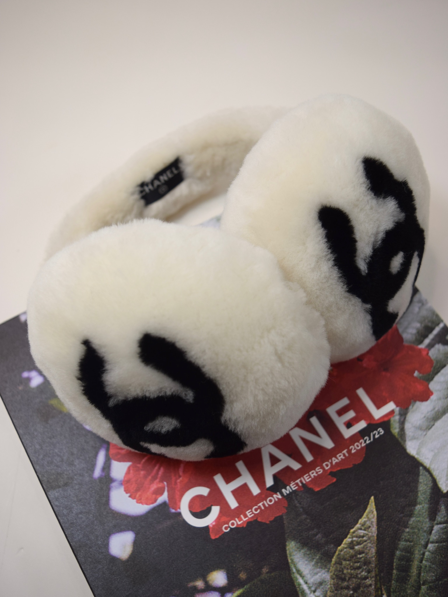 Chanel white furry earmuffs with black CC logo 2021